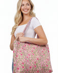 Woman holding a pink floral bag against a white wall