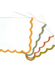 A set of scallop paper beverage napkins with colorful edges in orange, red, green, and yellow.