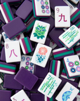 A pile of Mahjong tiles with purple backs, green and magenta borders, and white faces featuring Chinese characters and floral patterns.