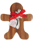 A gingerbread man shaped wooden cutting board gift set on a white background, featuring a silver metal holiday spreading tool tied with a red ribbon and a gift tag that reads 'Holiday CUTTING BOARD GIFT WITH SPREADER'.
