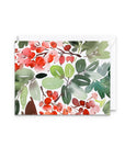 A square greeting card with a watercolor botanical pattern of red berries and green leaves, shown with a white envelope behind it on a white background.