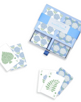 Set of playing cards with floral designs in a blue box on a white background