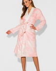 Woman wearing a pink floral robe on a white background