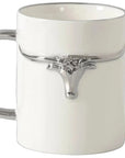 White ceramic mug with silver handle and decorative element on a light gray background