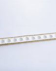 Long, narrow white dish with gold rim on a light gray background