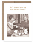 A vintage birthday card with a black and white photo of two women sitting together. The inside of the card has a text message.