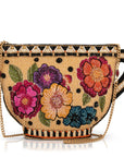 Woven handbag with floral designs and a gold chain on a white background