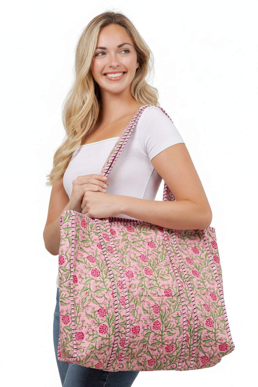 Woman holding a pink floral bag against a white wall