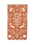Dinner napkin with white forest pattern on a rust-colored background