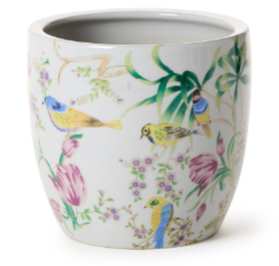 A white ceramic planter pot decorated with a delicate hand-painted style illustration of birds, flowers, and leaves in green, pink, yellow, and blue.