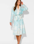 Woman wearing a light blue floral robe on a white background