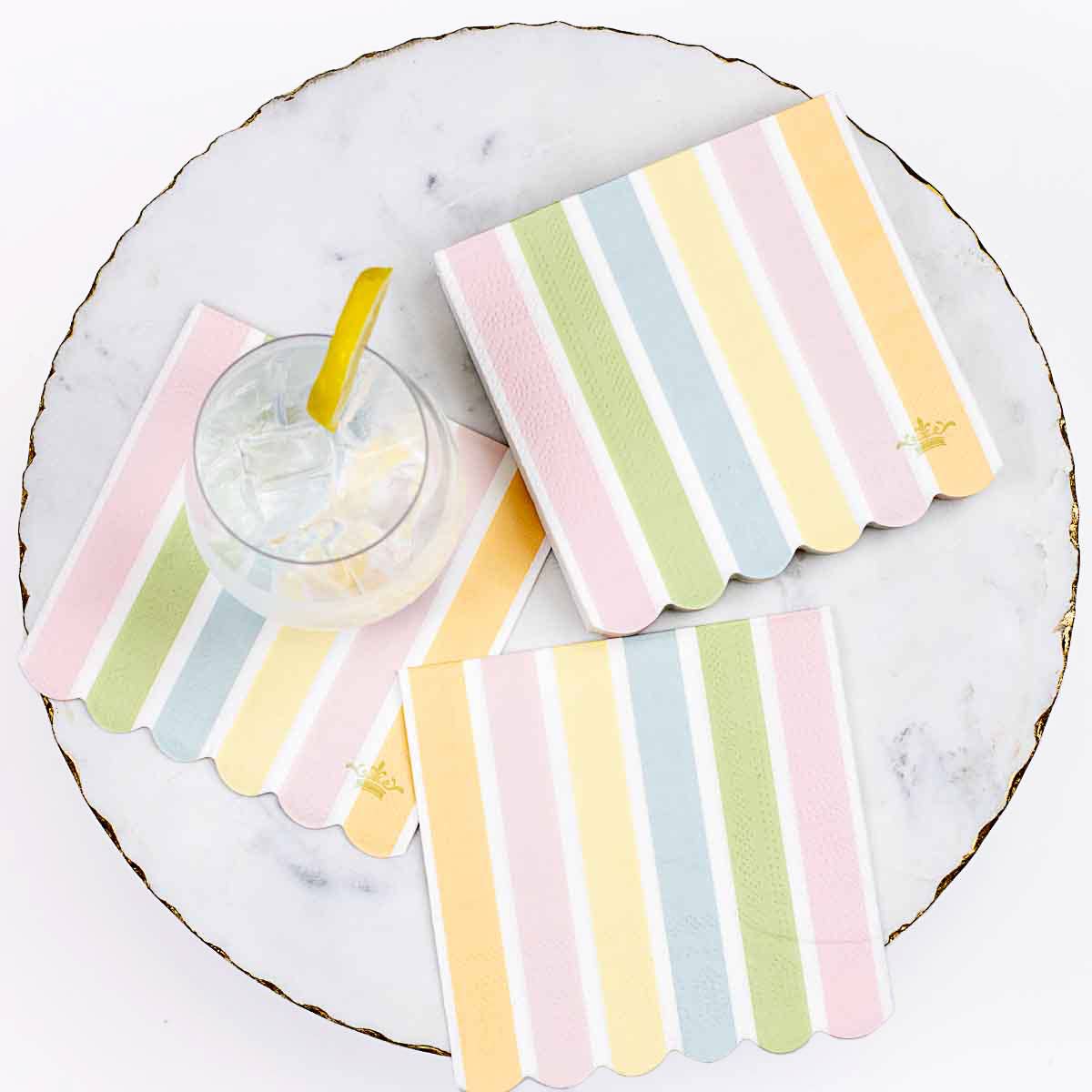 Pastel striped coasters on a marble surface with a glass of lemonade.