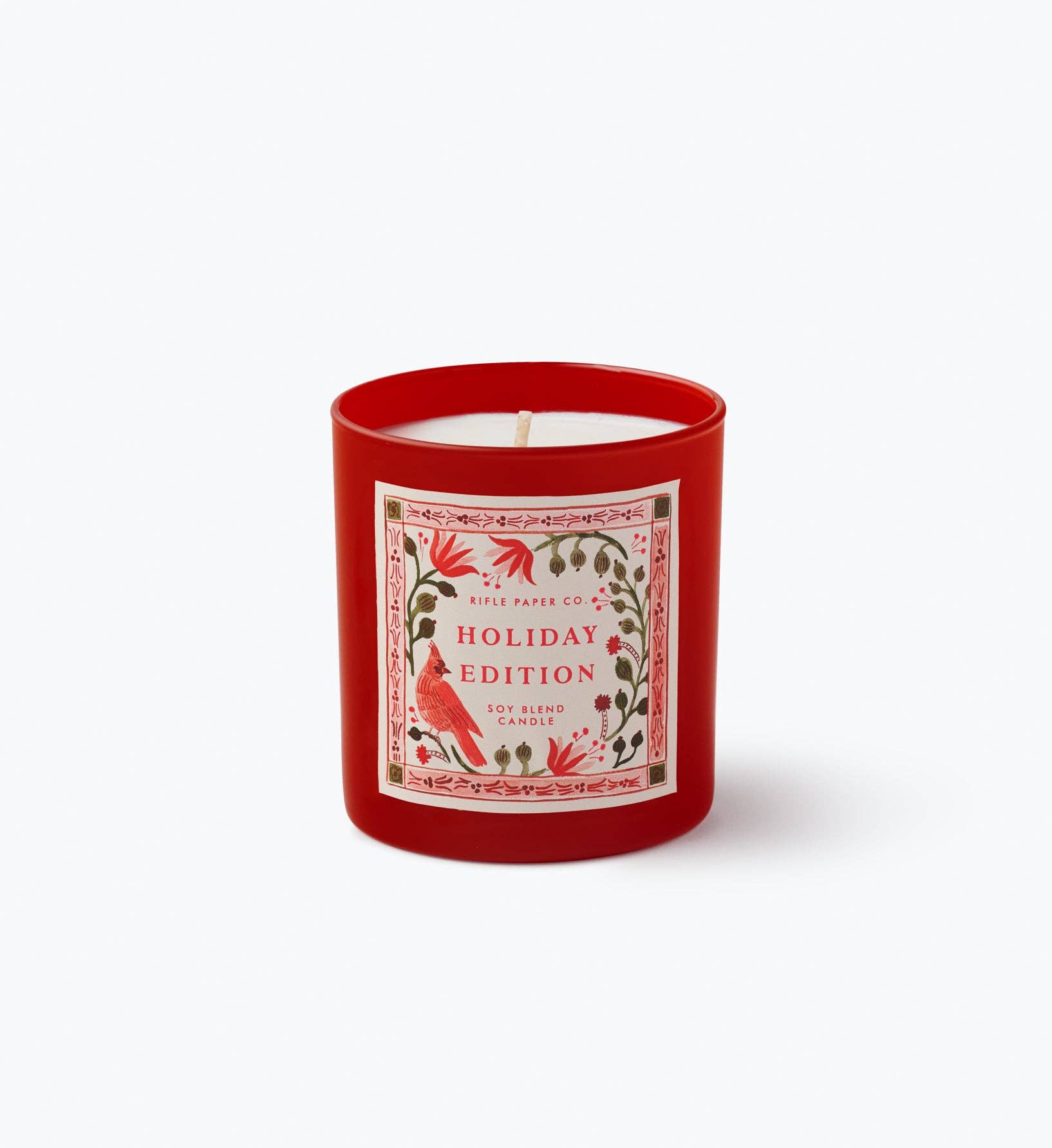 Red holiday edition candle with decorative label on a white background