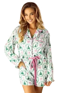Woman wearing a festive pajama set in a room decorated for Christmas.
