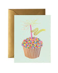 Greeting card with a cupcake illustration and 'Happy Birthday' text, accompanied by a brown envelope.