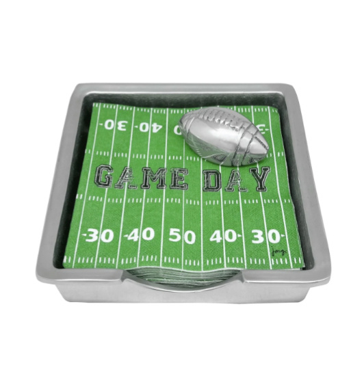 A rectangular silver napkin box with a green napkin featuring a football and the text 'Game Day' on the napkins.