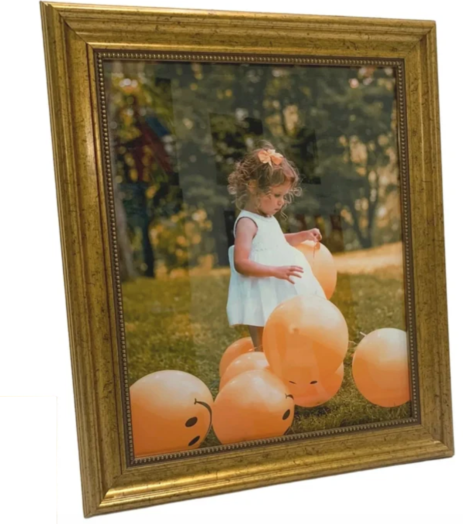 A square framed custom photo print with a distressed gold frame, featuring a photograph of a young girl in a white dress playing with orange balloons on a grassy lawn.