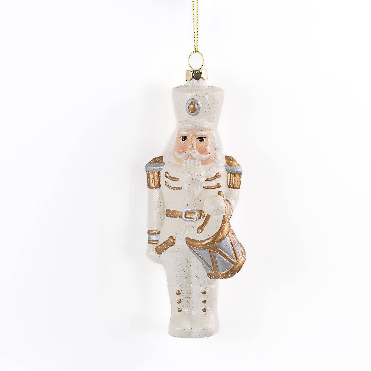 A frosted glass Christmas nutcracker ornament with gold and silver accents, hanging from a gold string against a plain white background.
