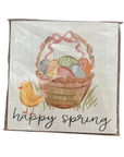 A square decorative sign or print wrapped in clear plastic, featuring an Easter basket filled with colorful eggs, a small yellow bird, and the words 'happy spring' on a light textured background.