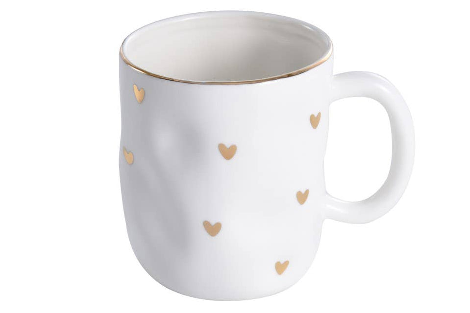 A white porcelain mug with gold-tone heart decorations
