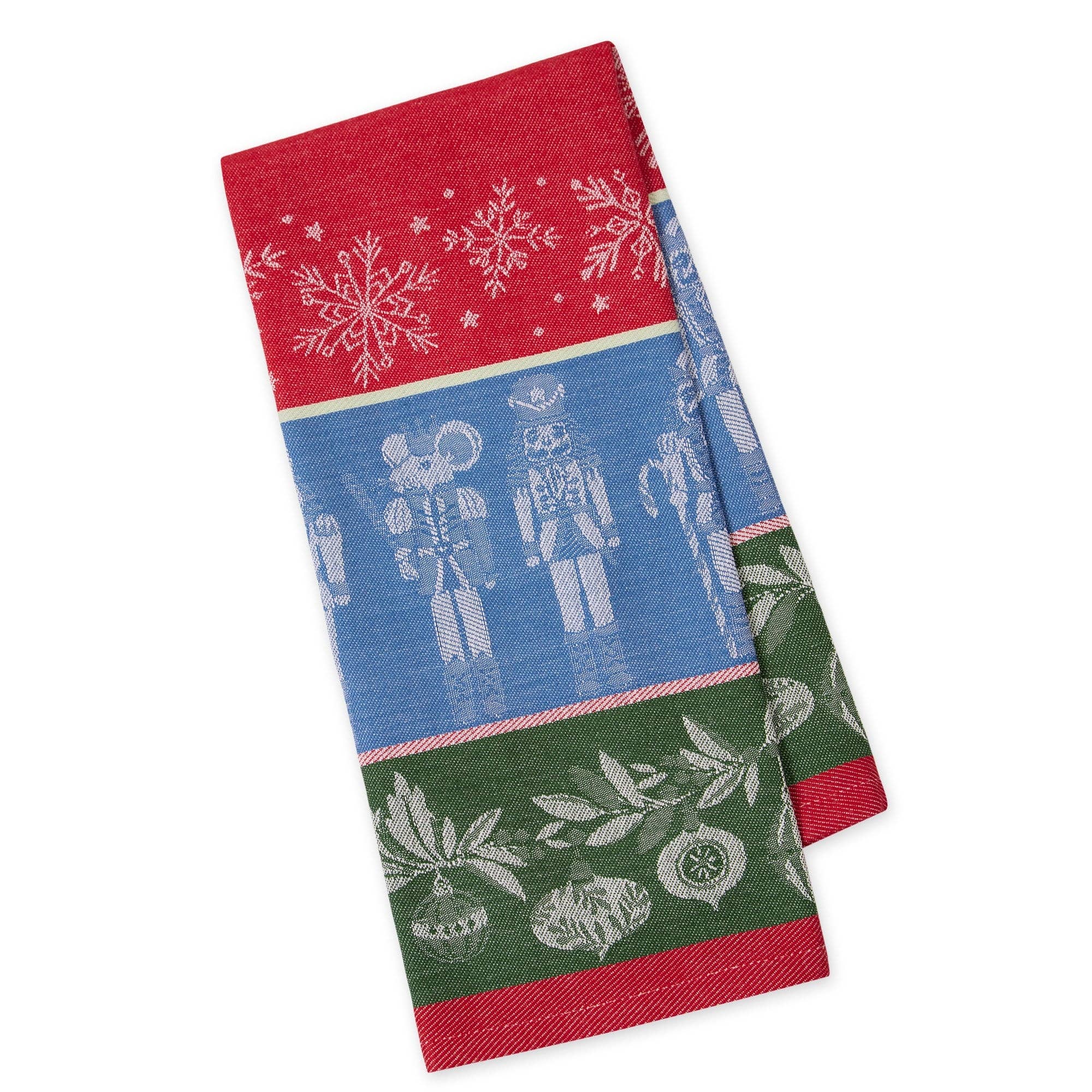 A folded holiday-themed woven towel featuring a red top section with white snowflakes, a blue middle section with white nutcracker figures, and a green bottom section with white ornaments and leaves.