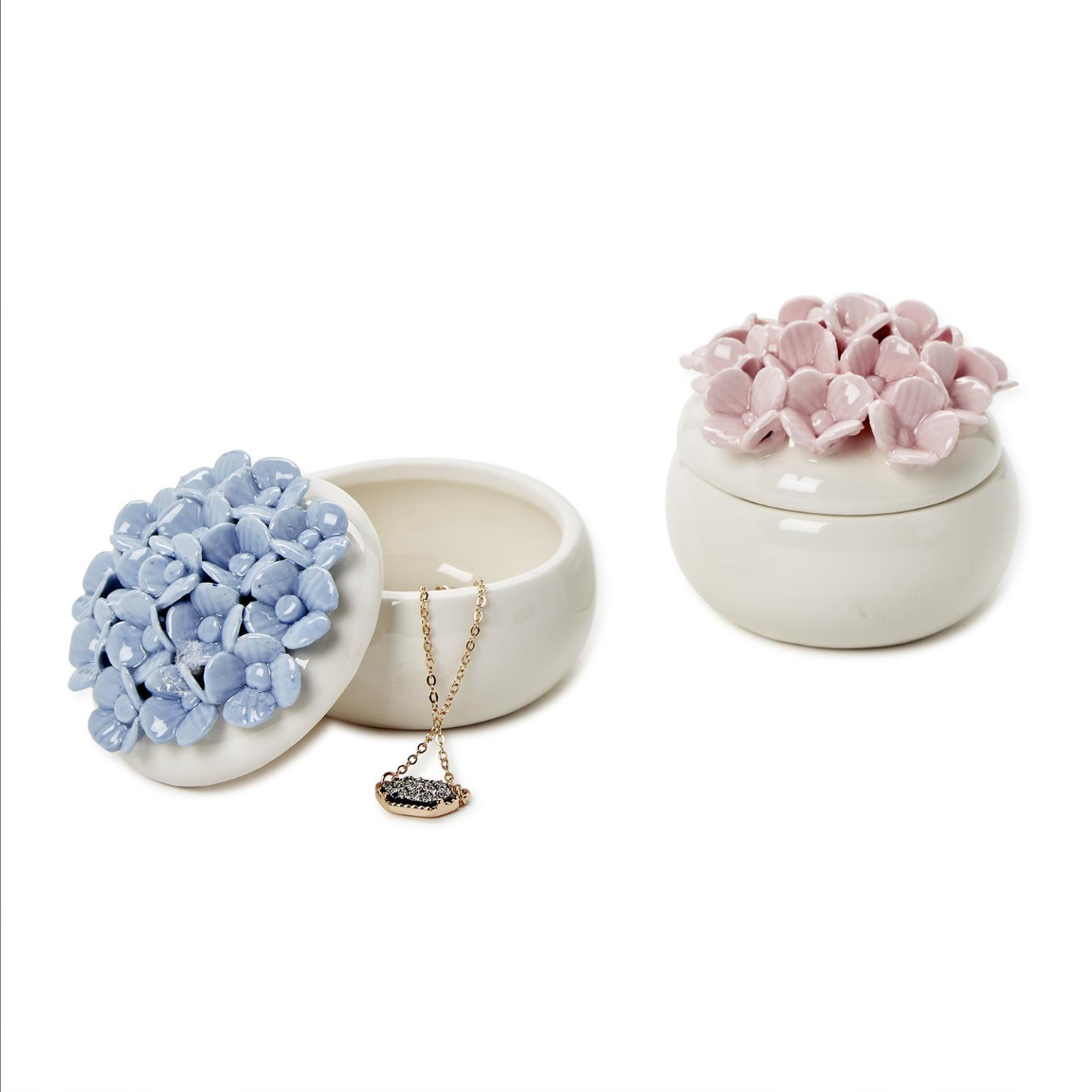 Two hand-painted porcelain jewelry boxes, one in blue and the other in pink, each with a floral design resembling hydrangea blooms on top.
