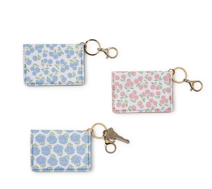 Three hydrangea print wallets with key chains, in different sizes, on a white background.
