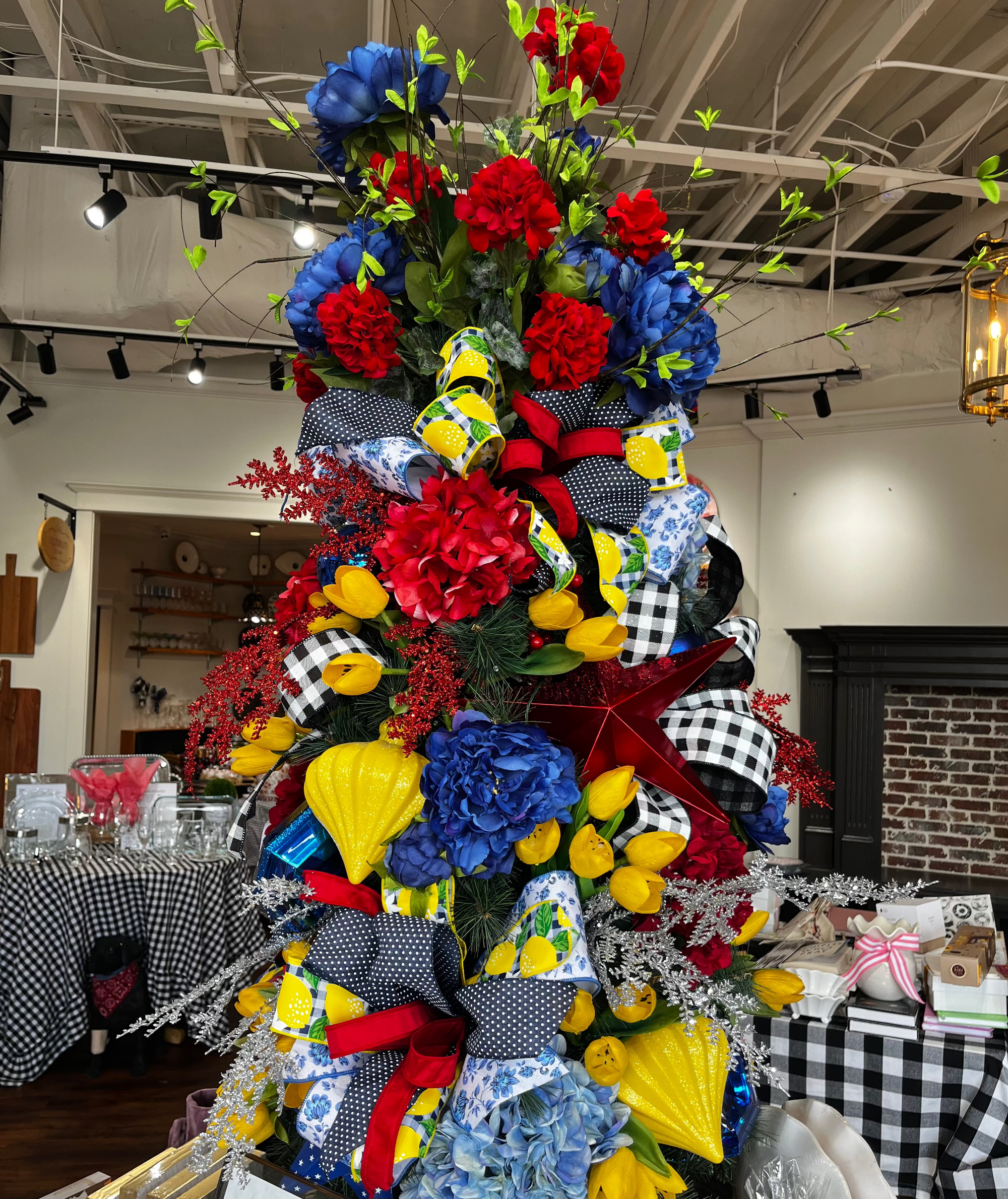 Decorative Christmas tree with colorful bows and flowers in a store setting