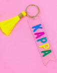 Keychain with 'Kappa' letters and yellow tassel on pink background