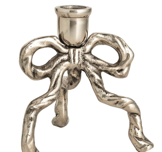 A metallic silver candle holder shaped like a stylized bow with three twisted legs and a cylindrical top cup, shown on a plain white background.