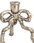 A metallic silver candle holder shaped like a stylized bow with three twisted legs and a cylindrical top cup, shown on a plain white background.