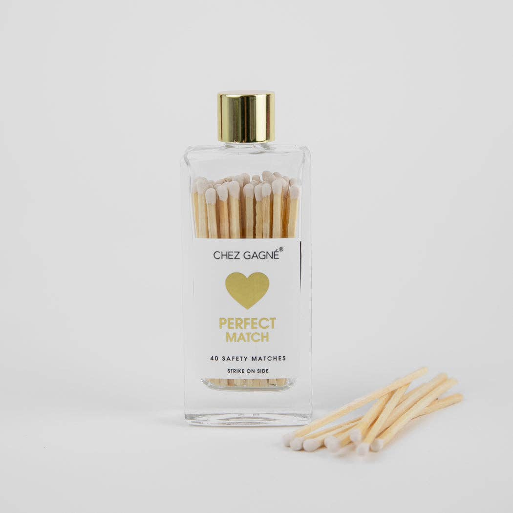 Bottle of matches with a gold cap and heart design on a white background