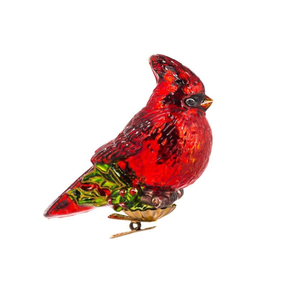 Red cardinal bird ornament with green branch on a white background