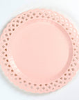 Pink paper plate with lace-like edge on a light gray background