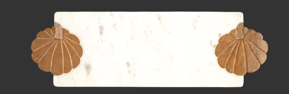Two brown marble pumpkins inlaid in a long, narrow white marble board.