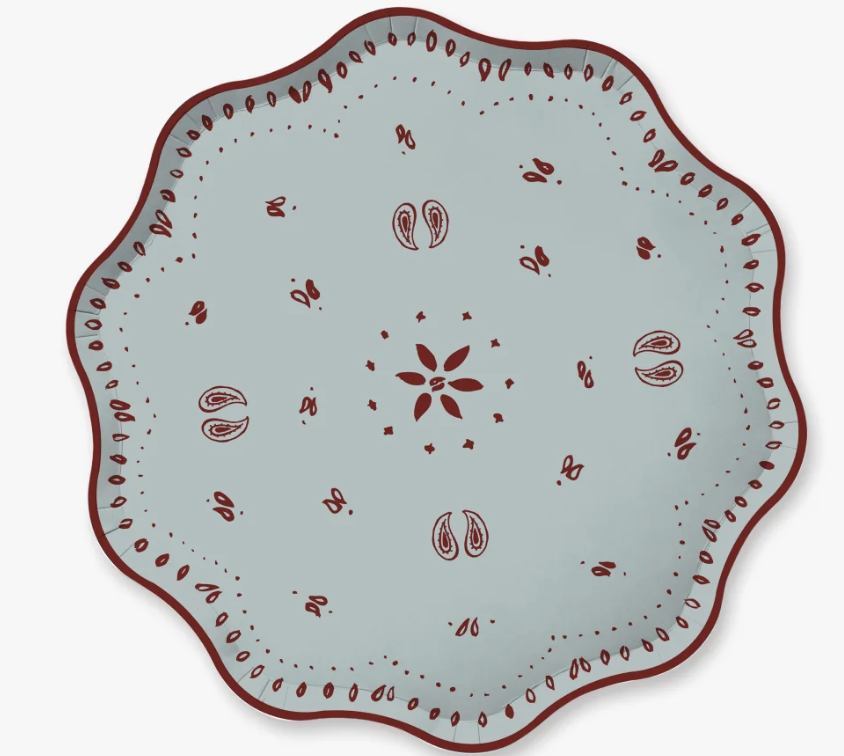 A scalloped paper plate with a light blue-gray and a dark red hand-painted folk pattern, shown from a top-down view on a white background.