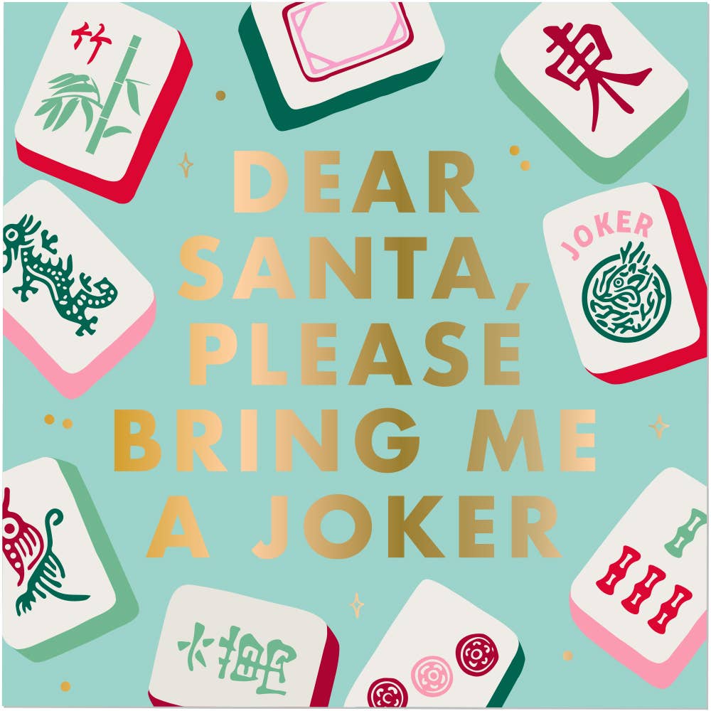 A cocktail napkin with the text 'DEAR SANTA, PLEASE BRING ME A JOKER' in large gold letters on a light aqua background, surrounded by illustrated mahjong-style tiles.