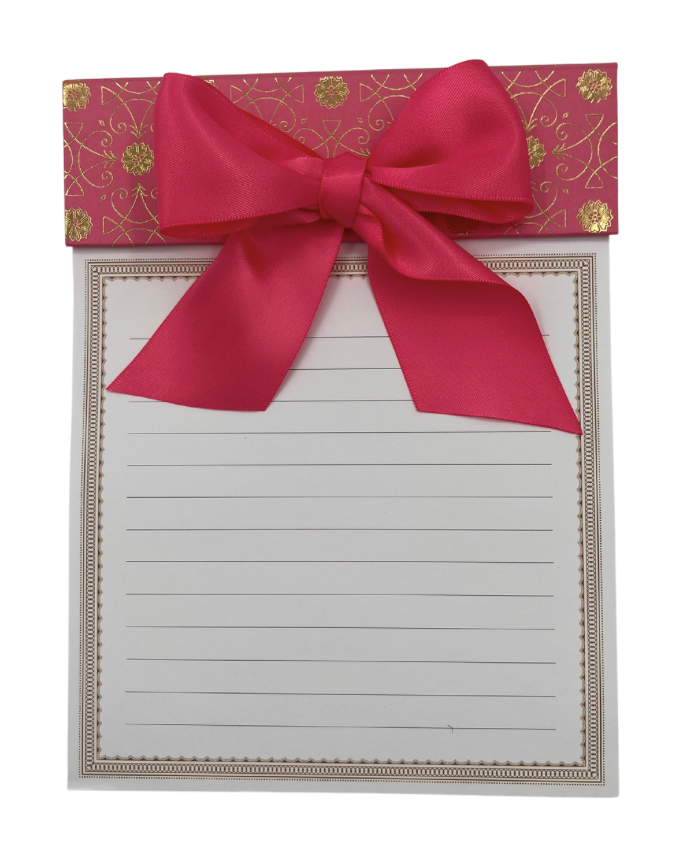 A large notepad with a hot pink ribbon bow and gold foil accents.