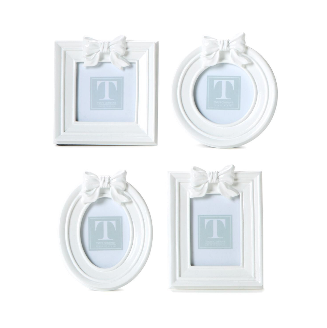 Set of four white picture frames with decorative bows on a white background