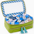Green case with blue striped lid containing colorful letter and number tiles.