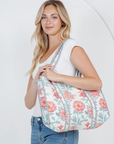 Woman holding a floral-patterned bag against a white background