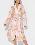 Woman wearing a pink floral robe on a white background