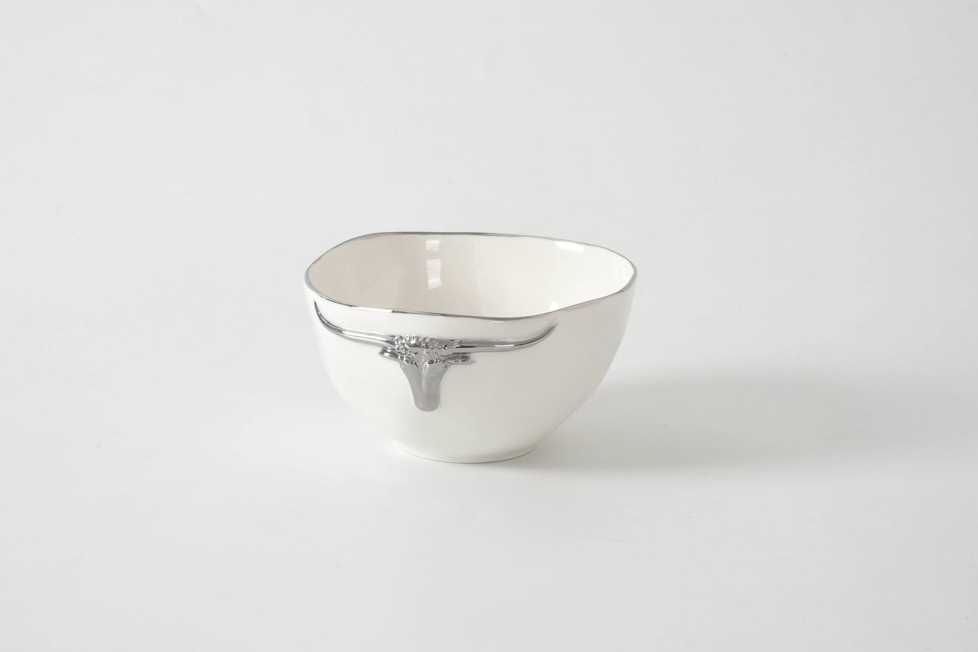 White ceramic bowl with decorative rim on a light gray background