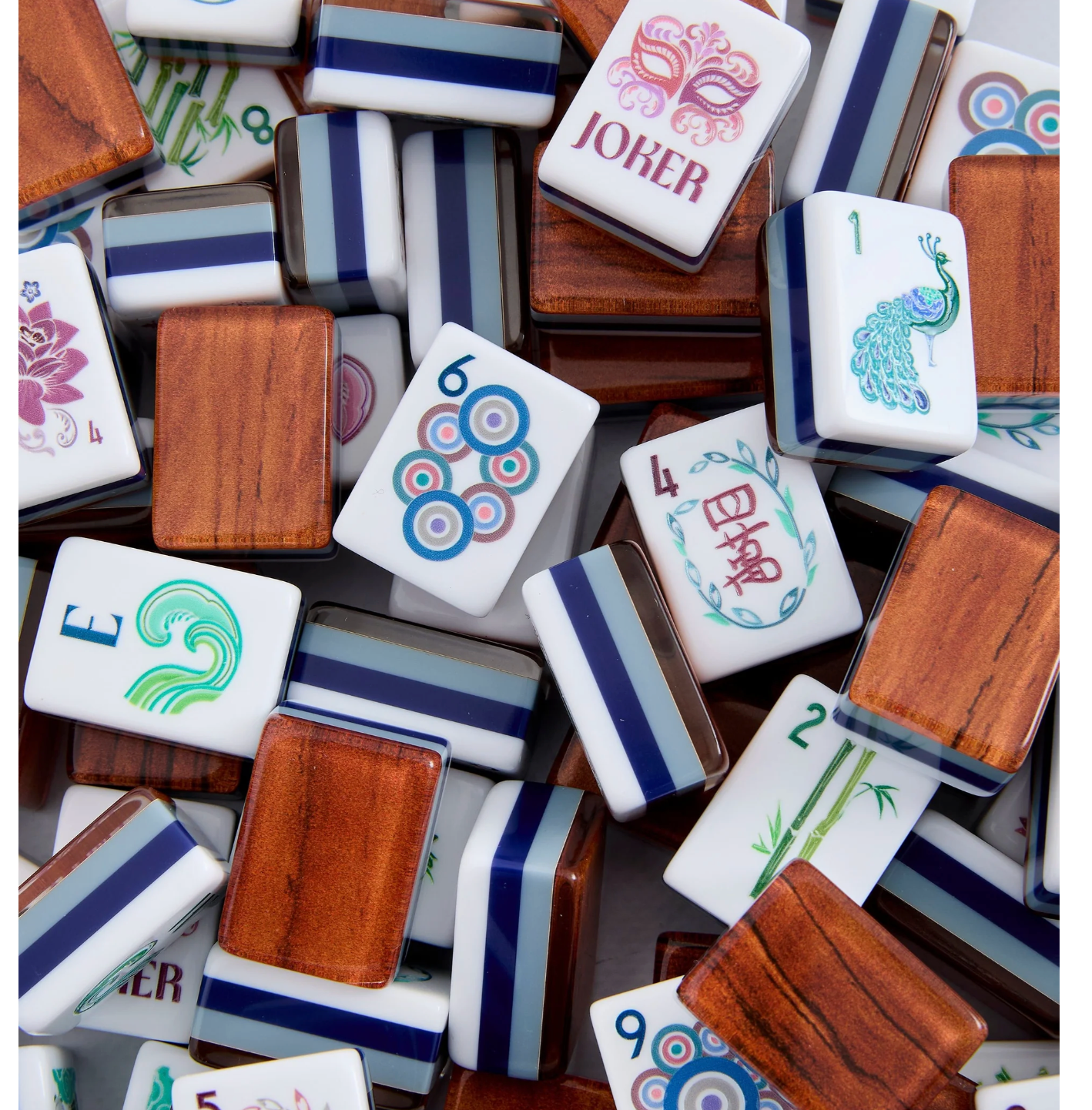 A pile of Mahjong tiles with white faces, blue striped borders, and wood-grain backs, featuring various symbols and characters including a peacock, bamboo, and Chinese characters.