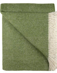 Green woven blanket with white fringe on a white background