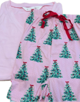 A folded pair of pink pajama shorts with an all-over green Christmas tree print and red drawstring waist, shown next to a matching solid pink folded shirt on a white background.