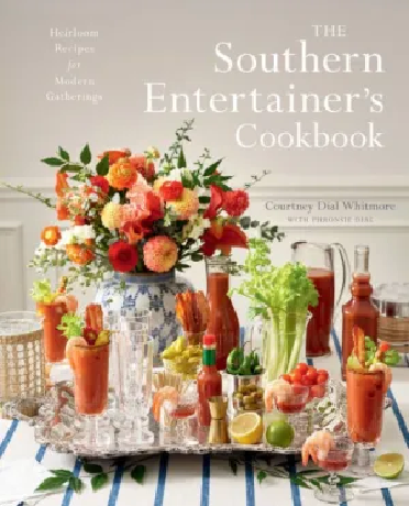 The cover of 'The Southern Entertainer's Cookbook' featuring a table set with various dishes and a floral arrangement, with the author's name and the phrase 'Heirloom recipes &amp; modern twists' displayed.