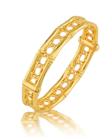 Gold bracelet with intricate design on a white background