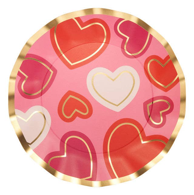 Round pink plate with red, gold, and white heart patterns on a white background