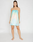 Woman wearing a strapless dress with a gradient design on a white background